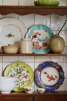 plates, bowls and vases are sitting on the shelves