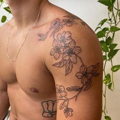 a shirtless man with flowers on his arm and chest is looking at the camera