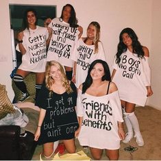 a group of women standing next to each other holding t - shirts with words on them