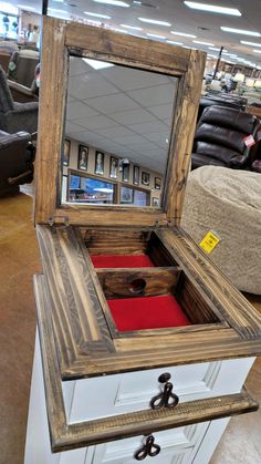 an open wooden box sitting on top of a white cabinet in a room filled with furniture