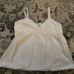 Brandy Melville Tank!! Never Worn W/ Tags!! White Brandy Melville Top, Cotton Camisole With Lace Trim For Day Out, Cotton V-neck Camisole For Brunch, Cotton Tank Top With Lace Trim For Day Out, Cotton Top With Lace Trim For Loungewear, Cotton Tops With Lace Trim For Loungewear, Cotton Lace Trim Top For Loungewear, Feminine White Tops For Loungewear, Camisole Tops With Lace Trim For Brunch