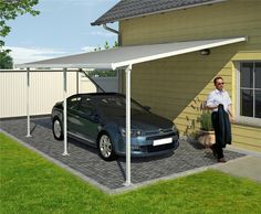 a man standing next to a car in front of a house with a white awning