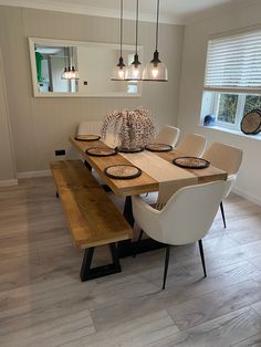 a dining room table with four chairs and a bench