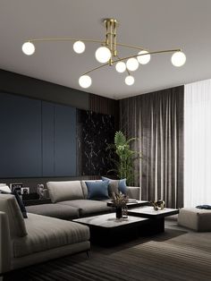 a living room with couches, tables and lamps hanging from the ceiling above them