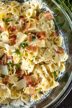 a glass bowl filled with pasta and bacon