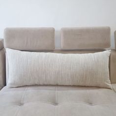 a white pillow sitting on top of a couch