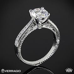 a white gold engagement ring with an intricate design and round brilliant cut diamond center stone