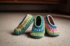 two crocheted slippers are sitting on the floor