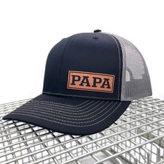 Introducing our Leather Patch PAPA Hat -- The Richardson 112 Hat is a classic and versatile accessory that combines style and functionality. Featuring a structured fit, a pre-curved visor, and an adjustable snapback closure, this hat provides a comfortable and customizable fit. Its timeless design, along with various color options, makes the Richardson 112 a go-to choice for casual wear, outdoor activities, or sports. Crafted with attention to detail, it's a reliable and stylish addition to any wardrobe. THE HAT: Classic trucker cap style built with the Richardson quality and fit you've come to expect. The Richardson 112 remains a best-seller and favorite cap for teams, fans, and brands alike. Richardson 112 Fabric: Cotton-Poly/Nylon Mesh Visor: Pre-curved Sweatband: Cotton Fit: Adjustable Richardson Hats, Hat Custom, Quality Hats, Grandparents Day, New Dads, Baseball Hat, Leather Patches, Gift Christmas, Trucker Cap