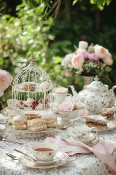 a table topped with tea cups and cakes