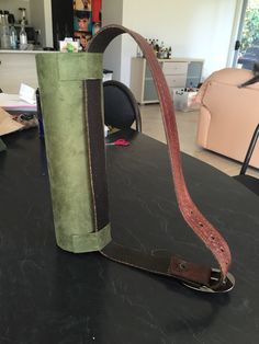 a green and brown bag sitting on top of a table next to a roll of paper