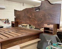 a large wooden bed frame sitting on top of a workbench in a shop