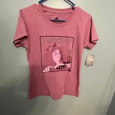 a pink t - shirt with the words i woke up on it hanging from a hanger