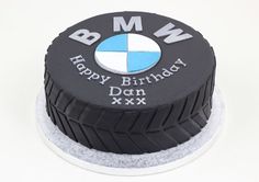 a black and white birthday cake with the bmw logo on it