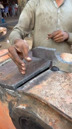 a man standing next to a piece of metal