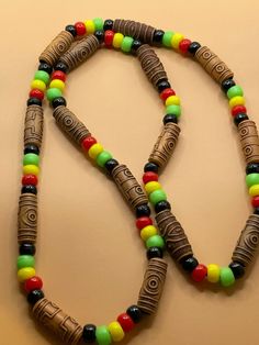 Jamaican Beaded Jewelry, Casual Brown Beaded Necklaces With Colorful Beads, Brown Beaded Necklace With Black Beads As Gift, Brown Beaded Necklaces With Black Beads For Gift, Brown Beaded Necklace With Black Beads For Gift, Festival Necklace With Round Wooden Beads, Casual Wooden Beads For Festival, Unique Adjustable Black Beaded Necklaces, Unique Adjustable Beaded Necklace With Black Beads