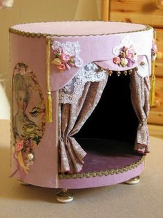 a doll house made to look like a princess's bed with curtains and flowers on it