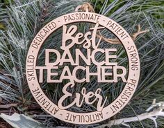 a wooden ornament with the words best dance teacher ever on it hanging from a pine tree