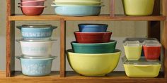 many bowls are stacked on top of each other in front of a shelf with glass containers