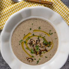 a white bowl filled with soup and topped with mushrooms