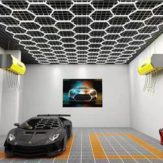 two sports cars are parked in an empty room with yellow lights on the ceiling and white walls