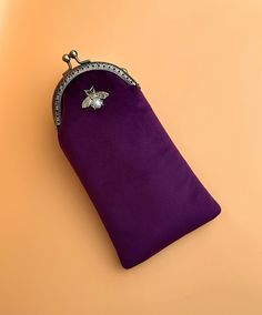 Gorgeous handmade purple velvet glasses case or pencil case. Suitable for reading glasses or sunglasses. - Bronze colour Kiss lock clasp - Dimensions: H:18.5cm X  W:10.5 cm approximately  - Padded  - The pattern of the lining inside of the bag may vary. But don't worry, I always make sure the  lining of the bag matches the outside beautifully. - Accessories not included Due to different monitor settings, colours may differ slightly from those pictured ! More available here: https://www.etsy.com/uk/listing/1622755655/ https://www.etsy.com/uk/listing/1633852389/ https://www.etsy.com/uk/listing/1654774618/ Purple Pencil Case With Pen Holders As Gift, Gift Purple Pencil Case With Pen Holders, Rectangular Purple Pencil Case, Purple Glasses, Glasses Pouch, Bronze Colour, Eyeglasses Case, Vintage Eyeglasses, Eye Wear Glasses