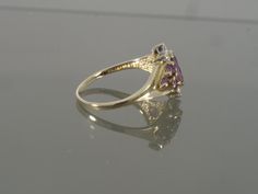 This gorgeous amethyst ring is sure to please! It is crafted of 18k yellow gold and features a stunning colored natural amethyst. This ring also features tiny round brilliant cut diamond accents on the top and bottom of the face. This would make a great Valentines Day, February Birthstone, or Anniversary gift. This ring will be shipped in a brand new gift box. RING SIZE: 7.25 (Sizable by your local jeweler) Metal: 18k Yellow Gold (Verified by acid test) Gemstone: 1 Marquise Natural Amethyst (app Yellow Gold Amethyst Ring With Round Cut Accent Stones, Yellow Gold Amethyst Ring With Accent Stones, Round Cut, Pear-shaped Purple Amethyst Ring With Prong Setting, Purple Pear-shaped Amethyst Ring With Prong Setting, Purple Pear-shaped Ring With Prong Setting, Fine Jewelry Purple Hallmarked Sapphire Ring, Purple Hallmarked Sapphire Ring Fine Jewelry, Purple Sapphire Ring Hallmarked Fine Jewelry, Fine Jewelry Yellow Gold Amethyst Ring With Accent Stones