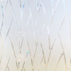 a window with frosted branches on it and a vase in the foreground holding flowers