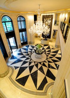 a large foyer with chandelier and black and white floor tiles on the floor