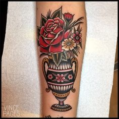 a tattoo on the leg of a woman with flowers in a vase