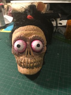 a fake human skull with red eyes and black hair