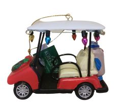 a red golf cart ornament hanging on a white wall with lights and decorations