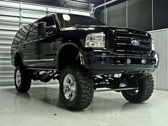 a large black truck parked in a garage