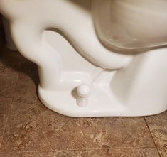 a white urinal sitting on top of a tiled floor