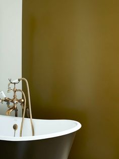 an old fashioned bathtub with faucet and shower head in a bathroom setting