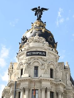 the top of a building with a sign on it that says metropolis is in front of a blue sky