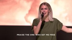 a woman singing into a microphone with the words praise the one who set me free