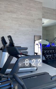 there is a gym with treads and exercise equipment in the foreground as well as a mirror