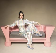 a woman sitting on top of a pink couch