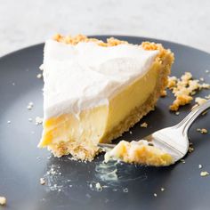 a piece of pie on a black plate with a fork and crumbs next to it