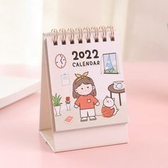 a desk calendar with a girl holding a cat