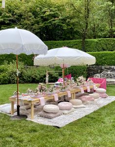 an outdoor picnic setting with umbrellas and pillows