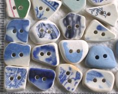 several blue and white ceramic buttons sitting on top of a ruler