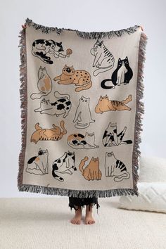 a person standing in front of a blanket with cats on it