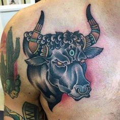 a bull tattoo on the back of a man's shoulder