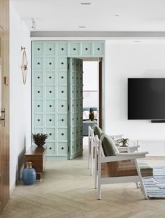 a living room filled with furniture and a flat screen tv mounted on the wall above it