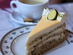 a piece of cake sitting on top of a plate next to a cup of coffee