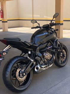 a black motorcycle is parked in front of a building with no one on it's bike