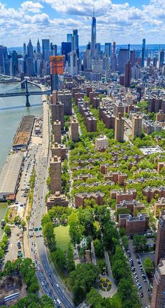 an aerial view of a city with tall buildings and lots of green trees in the foreground