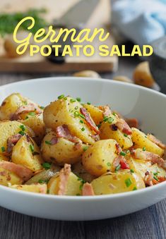 a white bowl filled with potatoes on top of a wooden table